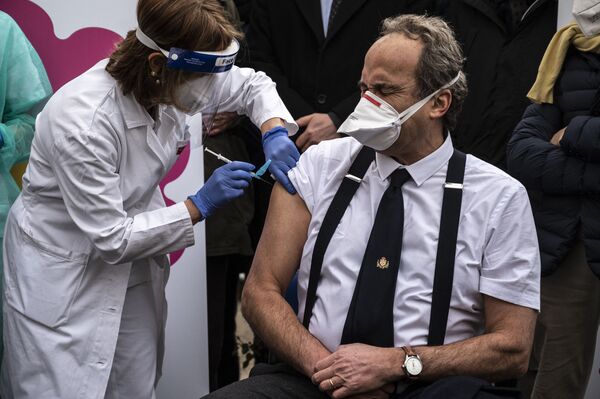 Врач, глава инфекционного отделения Джованни Ди Перри во время вакцинации в больнице Амедео ди Савойя в Турине, Италия - Sputnik Latvija