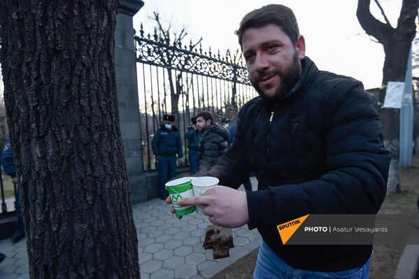 Мужчина с чаем на митинге оппозиции перед зданием Национального собрания Армении (3 марта 2021). Еревaн - Sputnik Латвия