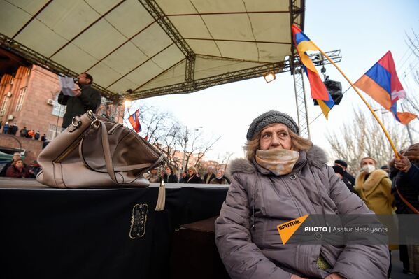 Aktīviste klausās opozīcijas politiķa Gegama Manukjana runu opozīcijas mītiņa laikā Bagramjana prospektā pie Armēnijas Nacionālās sapulces ēkas, 3. marts, Erevāna - Sputnik Latvija