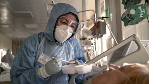 Медсестра кормит пациента в отделении реанимации - Sputnik Латвия
