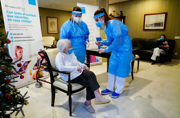 Сотрудницы дома престарелых с пациенткой перед вакцинацией в Мадриде, Испания - Sputnik Латвия
