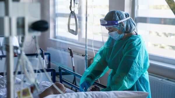 Медсестра оказывает помощь пациенту с COVID-19 в палате интенсивной терапии в коронавирусном отделении Даугавпилсской региональной больницы - Sputnik Латвия