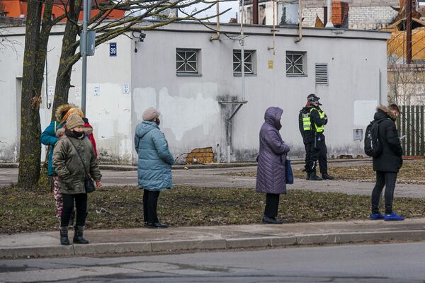 Cilvēki rindā ievēro distanci, netālu dežurē policija - Sputnik Latvija