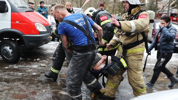 Спасатели выносят ребенка, пострадавшего при взрыве жилого дома в подмосковном городе Химки - Sputnik Латвия