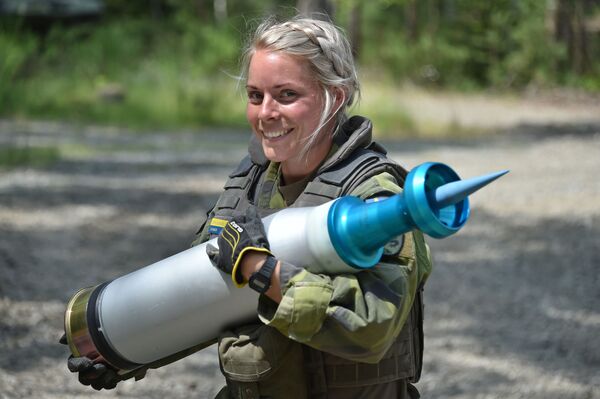 Женщина-военнослужащий армии Швеции несет снаряд во время танковых испытаний Strong Europe - Sputnik Latvija