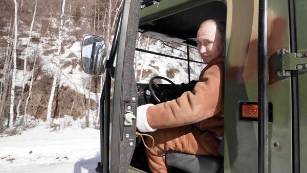Президент РФ Владимир Путин управляет вездеходом во время прогулки в тайге - Sputnik Латвия