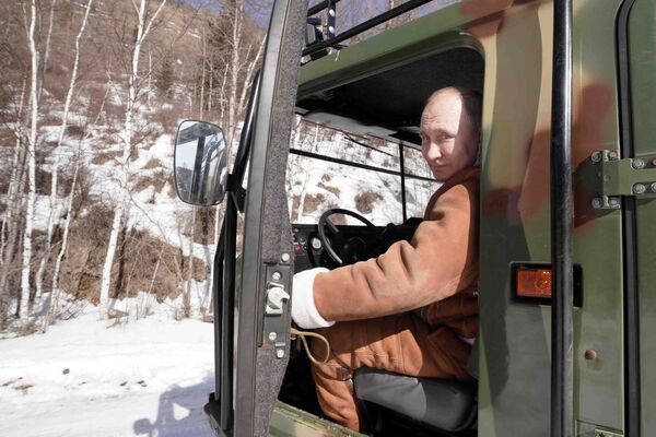 Президент РФ Владимир Путин управляет вездеходом во время прогулки в тайге - Sputnik Латвия