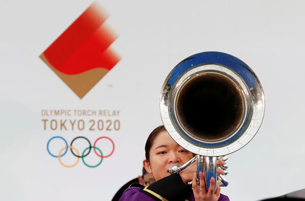 Участник оркестра  играет на музыкальном инструменте во время эстафеты олимпийского огня в Токио-2020 в префектуре Фукусима, Япония - Sputnik Латвия