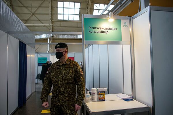 Военный у стойки предвакцинационных консультаций. - Sputnik Латвия