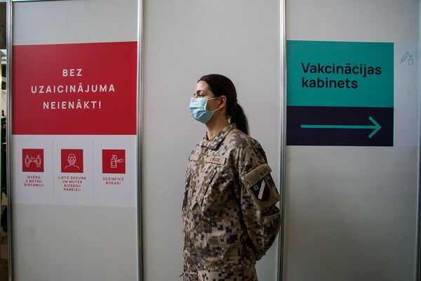 Военная у входа в кабинет вакцинации. - Sputnik Латвия