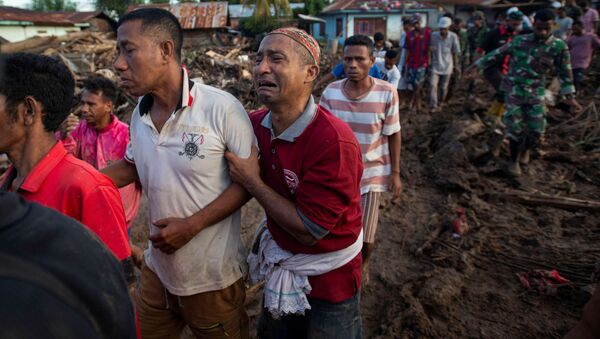 Люди оплакивают родственников, погибших в результате стихийного бедствия в индонезийской провинции Восточная Нуса - Тенггара - Sputnik Латвия