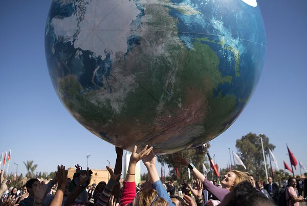 Члены всемирной конференции ООН по вопросам изменения климата с макетом Земли. - Sputnik Латвия