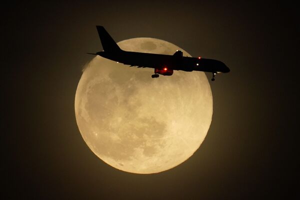 Самолет на фоне восходящей луны в американском Луисвилле - Sputnik Латвия
