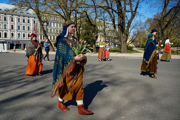 Женщины и мужчины в национальных костюмах в День восстановления независимости Латвии - Sputnik Латвия