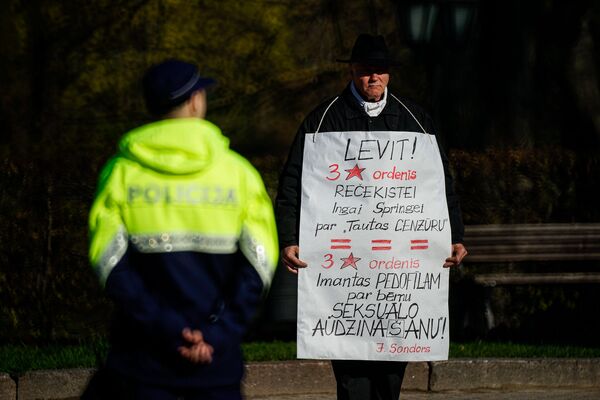 Латвийский антиглобалист Сигурдс Граудиньш с плакатом в День восстановления независимости Латвии - Sputnik Латвия