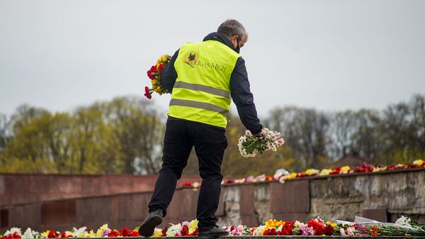  Сотрудник  Rīgas meži раскладывает цветы у памятника Освободителям - Sputnik Латвия