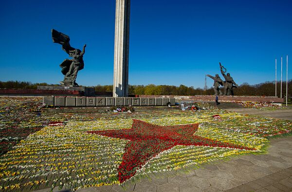 Sarkanā zvaigzne no ziediem pie Uzvaras pieminekļa, ko izkārtojuši brīvprātīgie - Sputnik Latvija