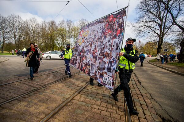 Policisti palīdz nest Nemirstīgajam pulkam veltīto plakātu - Sputnik Latvija