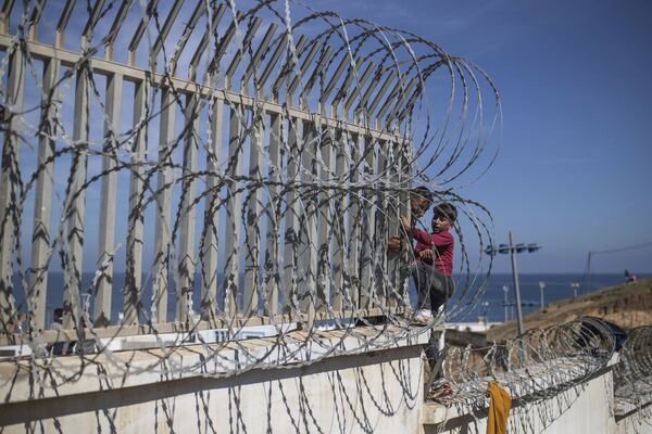 Мигранты перелезают через забор на границе Марокко и Испании. За сутки границу пересекли шесть тысяч человек. - Sputnik Латвия