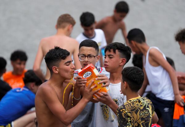 Марокканцы пьют сок после пересечения границы в Сеуте, Испания. - Sputnik Латвия