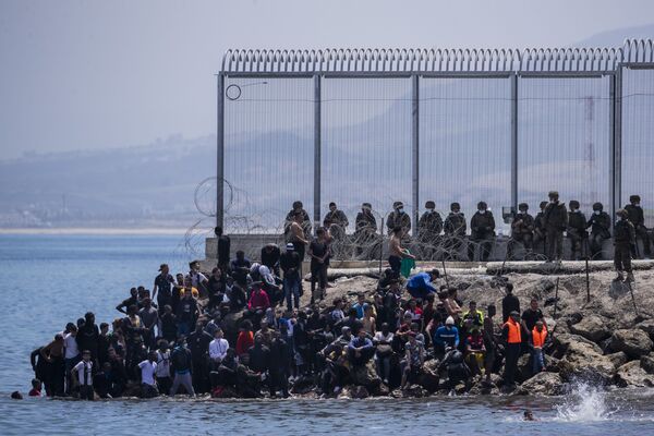 Migranti pie robežžoga starp Maroku un Spānijas anklāvu Seuta, 2021. gada 18. maijā. - Sputnik Latvija
