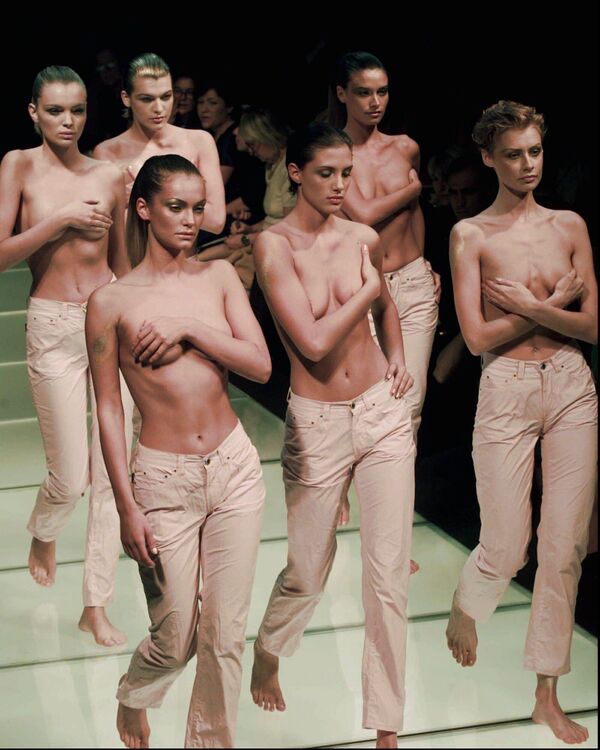 Группа моделей с обнаженной грудью, одетых в джинсы последнего производства Джанфранко Ферре, появляются на подиуме во время показа его весенне-летней коллекции в Милане, 1996 год. - Sputnik Латвия
