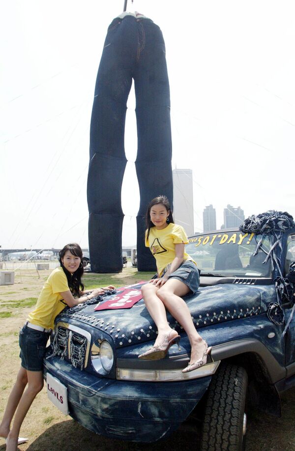 Южнокорейские модели позируют перед огромными синими джинсами в Сеуле. - Sputnik Латвия