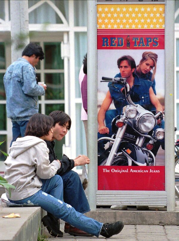 Китайская пара сидит рядом с американской парой, рекламирующей джинсы в телефонной будке, Пекин. - Sputnik Латвия