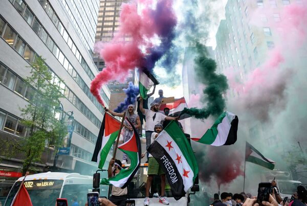 Демонстранты держат палестинский и сирийский флаги в поддержку Палестины в центре Манхэттена, 18 мая 2021 года. - Sputnik Латвия