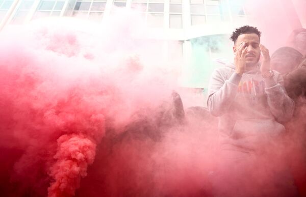 Реакция пропалестинского демонстранта, стоящего в дыму во время акции протеста в Лондоне, 15 мая 2021 года. - Sputnik Латвия