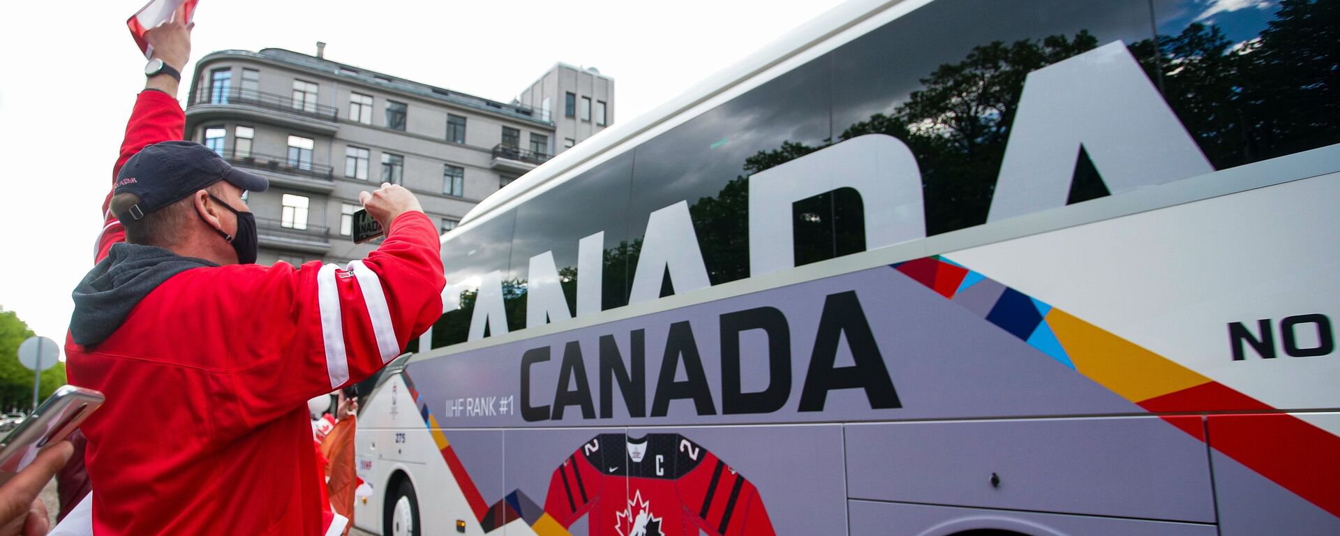 Болельщики сборной Канады приветствуют автобус с игроками команды перед матчем чемпионата мира по хоккею 2021 против сборной Латвии. - Sputnik Латвия, 1920, 26.05.2021