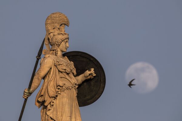 Mēness redzams aiz sengrieķu dievietes Atēnas statujas virs Atēnu akadēmijas ēkas Grieķijā - Sputnik Latvija