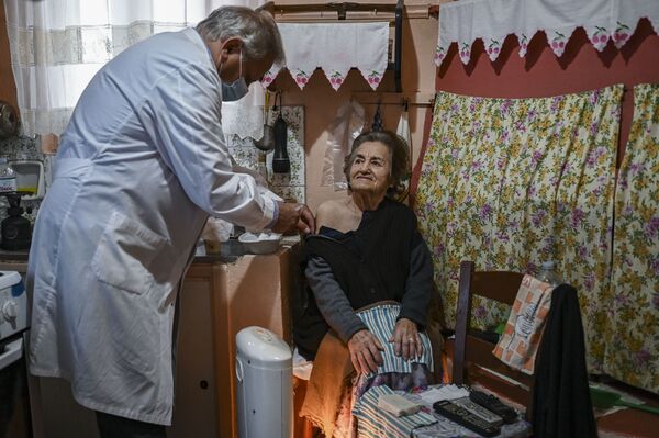 Доктор Анаргирос Мариолис вакцинирует пожилую женщину от COVID-19 на острове Элафониссос - Sputnik Латвия