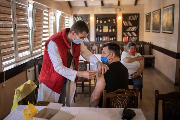 Мужчина получает дозу китайской вакцины Sinopharm против коронавирусной болезни (COVID-19) в ресторане в Крагуеваце, Сербия - Sputnik Латвия