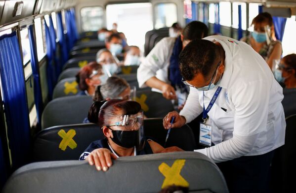 Сотрудники получают дозу вакцины от коронавируса Pfizer-BioNTech (COVID-19) в автобусе в Сьюдад-Хуарес, Мексика - Sputnik Латвия