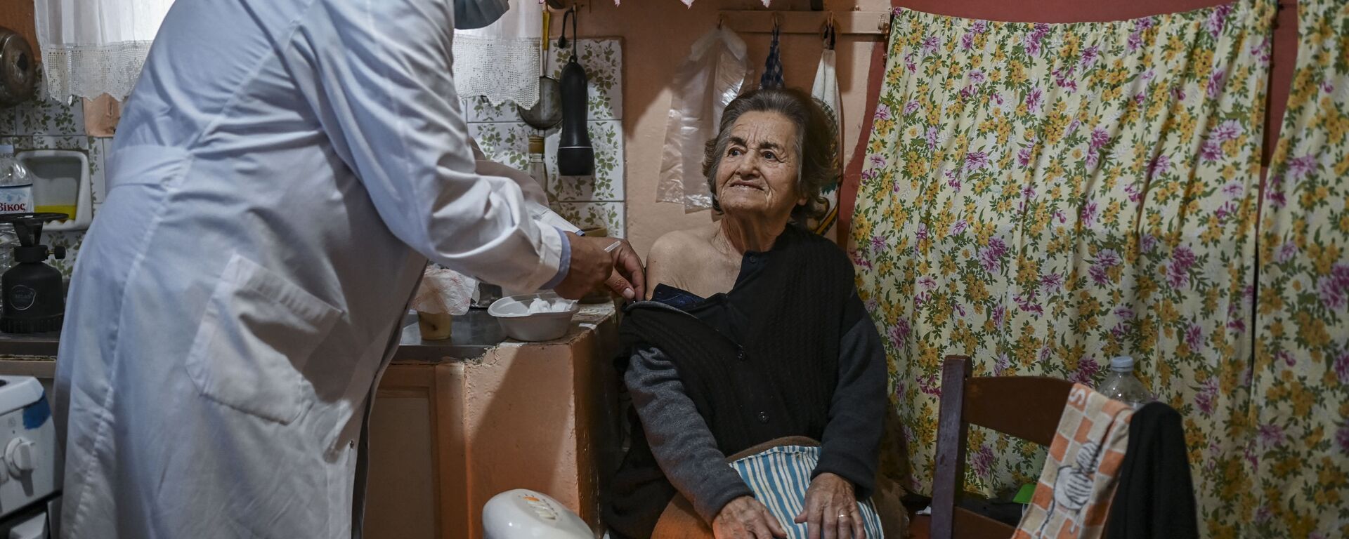Доктор Анаргирос Мариолис вакцинирует пожилую женщину от Covid-19 на острове Элафониссос - Sputnik Латвия, 1920, 17.06.2021