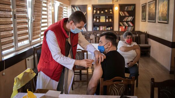 Мужчина получает дозу китайской вакцины Sinopharm против коронавирусной болезни (COVID-19) в ресторане в Крагуеваце, Сербия - Sputnik Латвия
