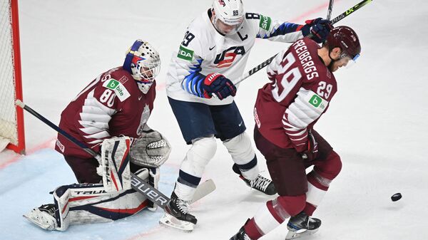 Слева направо: вратарь Матис Кивлениекс (Латвия), Джастин Абделкейдер (США) и Ральф Фрейбергс (Латвия) в матче группового этапа ЧМ по хоккею 2021 - Sputnik Латвия
