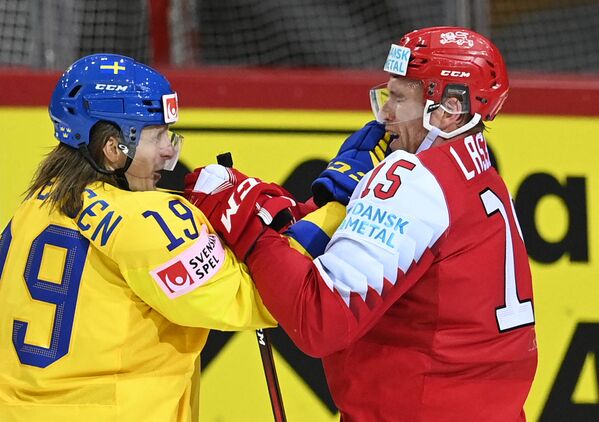 Нападающий Швеции Маркус Серенсен и защитник Дании Матиас Лассен в матче группового этапа чемпионата мира по хоккею - 2021 между сборными Дании и Швеции - Sputnik Латвия