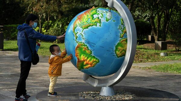 Женщина и ребенок у глобуса в китайском городе Ухань - Sputnik Латвия