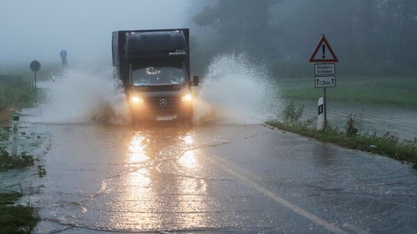 Автомобиль едет по дороге, пострадавшей от наводнения, Германия - Sputnik Латвия