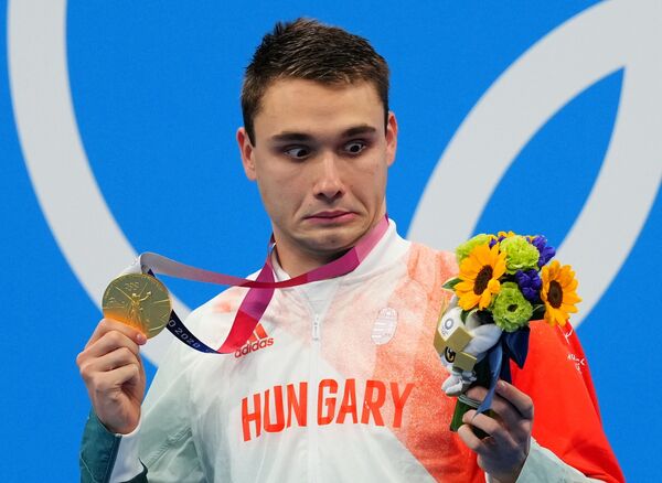 Венгерский пловец Кристоф Милак, победивший в заплыве баттерфляем на 200 метров, позирует со своей золотой медалью на пьедестале почета в Токио. - Sputnik Латвия