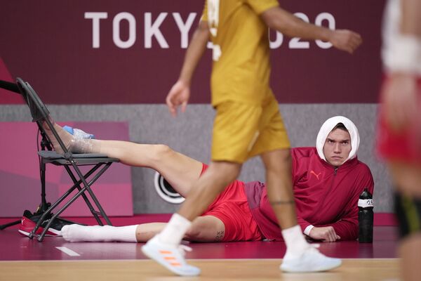 Датчанин Лассе Андерссон наблюдает за игрой после травмы во время гандбольного матча на летних Олимпийских играх - 2020. - Sputnik Латвия