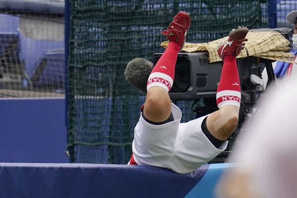 Японец Ю Ямамото падает через стену во время матча по софтболу. - Sputnik Латвия