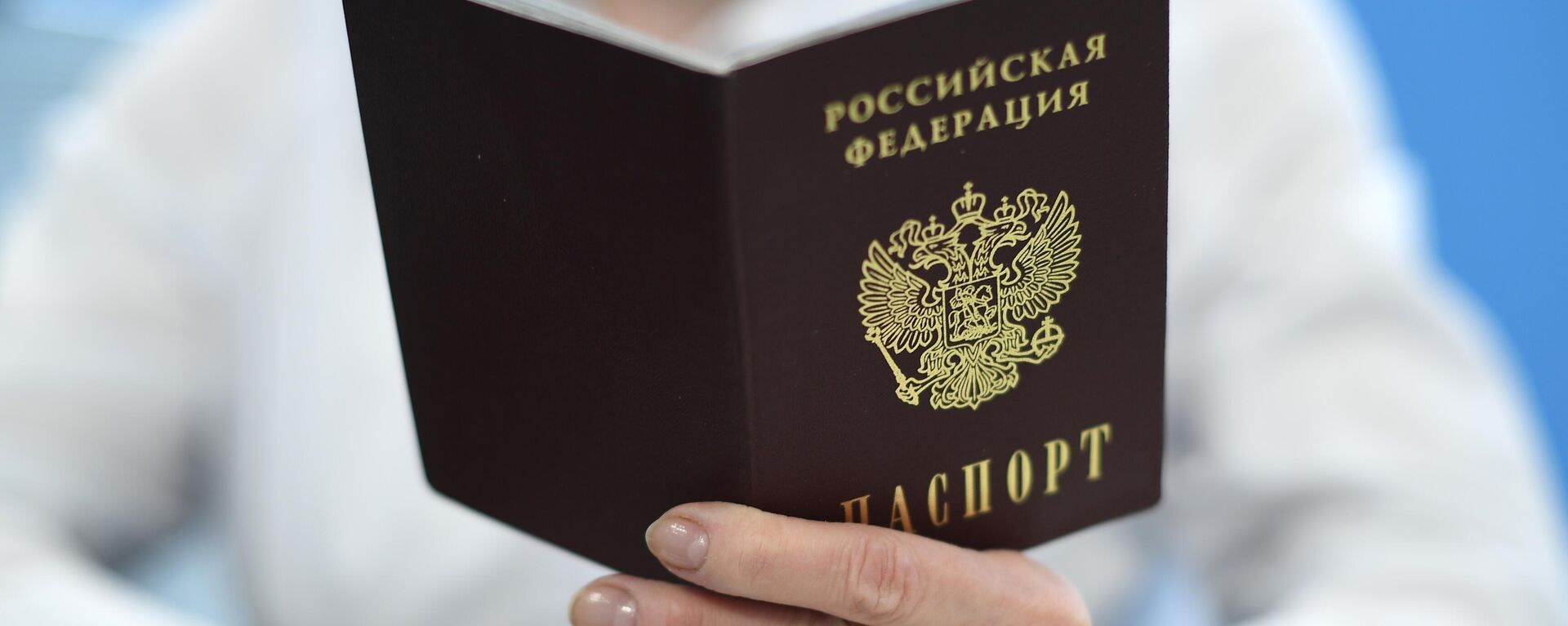 Сотрудник ПФР держит в руках паспорт РФ - Sputnik Латвия, 1920, 08.05.2023