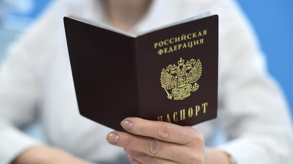 Сотрудник ПФР держит в руках паспорт РФ - Sputnik Латвия