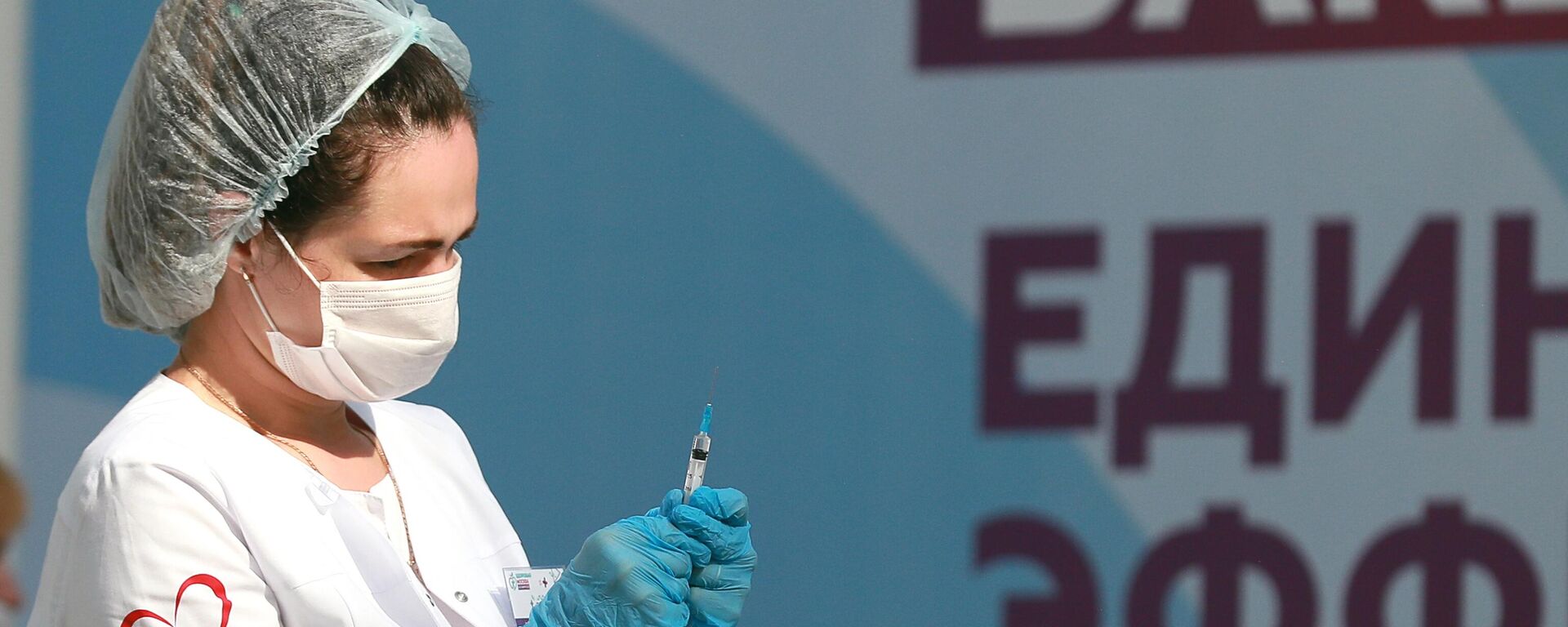 Медицинский работник держит в руках шприц с вакциной Гам-Ковид-Вак (Спутник V) от COVID-19 - Sputnik Латвия, 1920, 23.09.2021