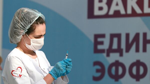 Медицинский работник держит в руках шприц с вакциной Гам-Ковид-Вак (Спутник V) от COVID-19 - Sputnik Латвия