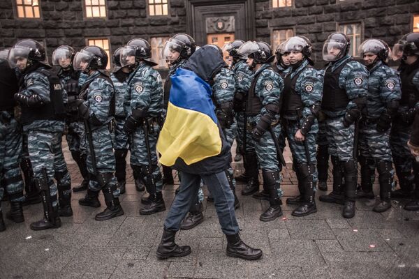 Ukrainas eiroinegrācijas atbalstītājs un milicijas darbinieki pie valdības ēkas Kijevā - Sputnik Latvija