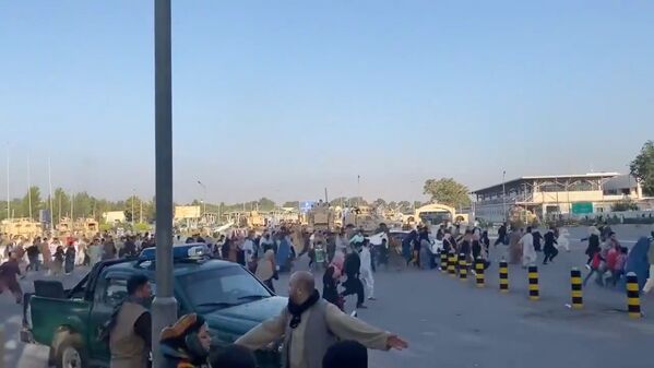 Люди бегут к терминалу Кабульского аэропорта после захвата президентского дворца группировкой &quot;Талибан*&quot;. - Sputnik Латвия
